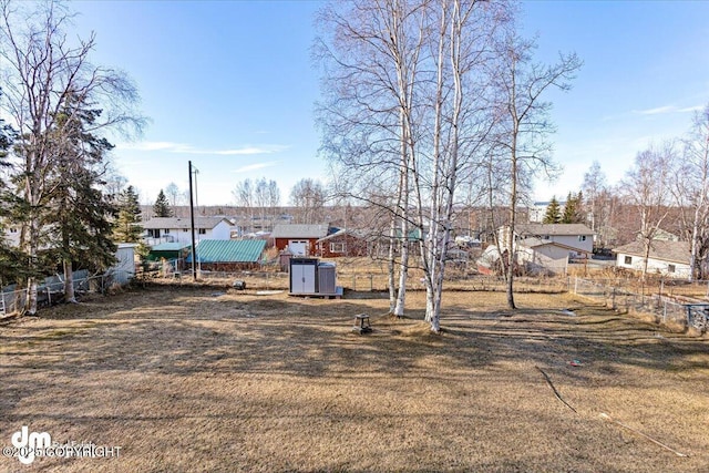 view of yard featuring a storage shed, fence, and an outbuilding