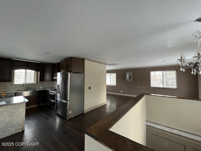 kitchen with electric range, dark wood-style flooring, stainless steel refrigerator with ice dispenser, and a wealth of natural light