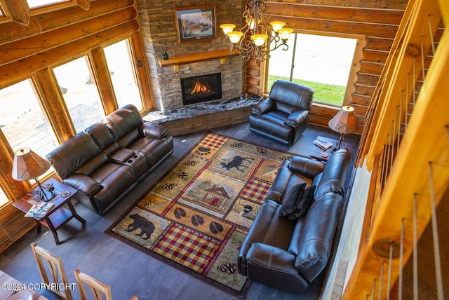 living area with wood finished floors, rustic walls, a fireplace, and an inviting chandelier