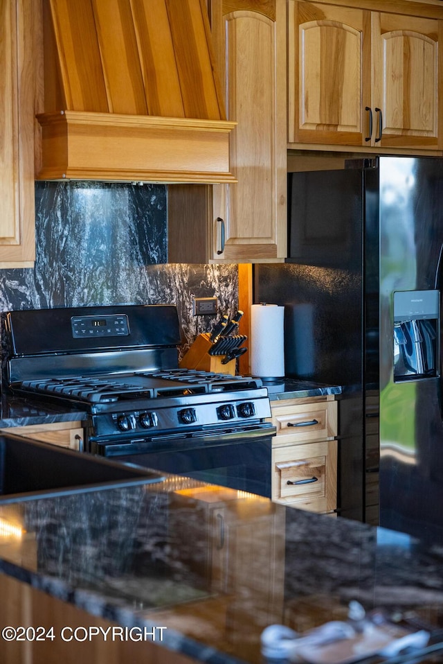 kitchen featuring black appliances, tasteful backsplash, and custom exhaust hood