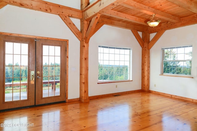 doorway to outside featuring french doors, visible vents, lofted ceiling with beams, wood finished floors, and baseboards