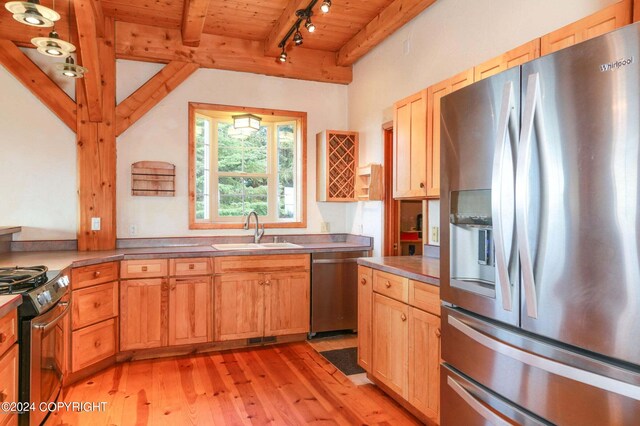 kitchen featuring wooden ceiling, light wood-style flooring, a sink, appliances with stainless steel finishes, and beamed ceiling