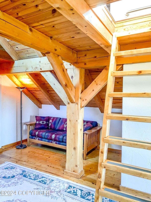 unfurnished bedroom featuring wood ceiling, vaulted ceiling with beams, and hardwood / wood-style flooring