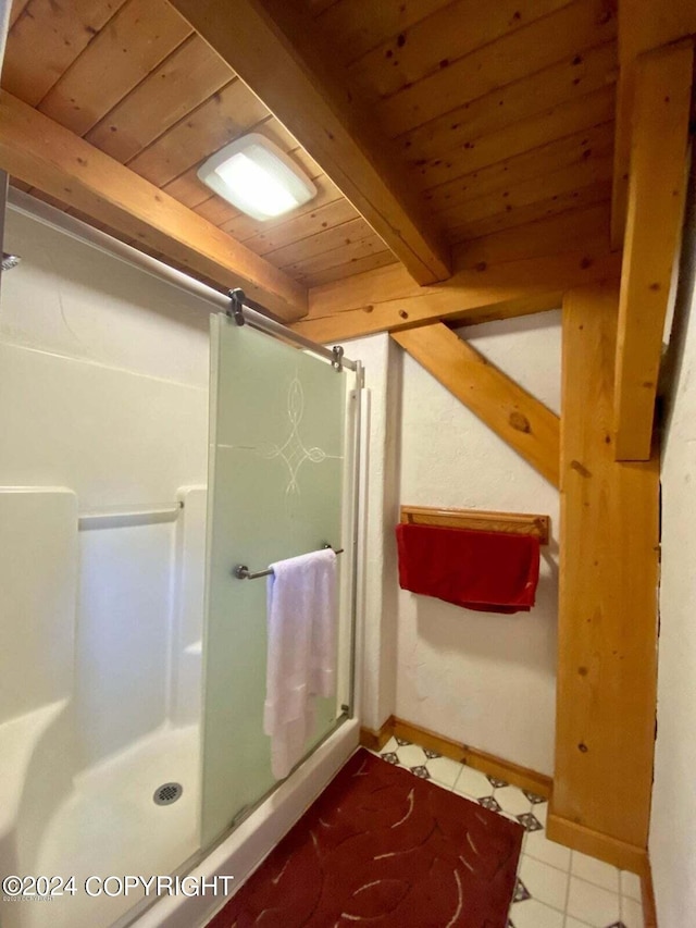 bathroom featuring wood ceiling, a shower stall, baseboards, and beam ceiling