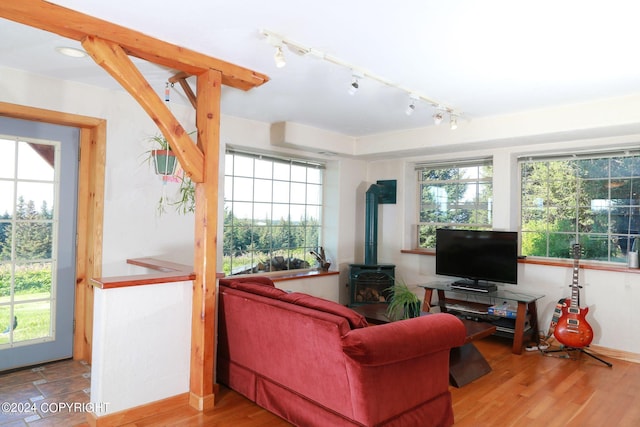 living room featuring a wood stove, baseboards, and wood finished floors