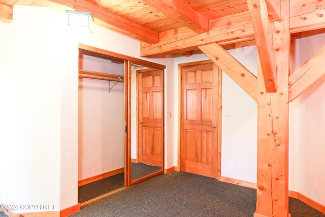 unfurnished bedroom featuring wood ceiling, carpet floors, beam ceiling, and baseboards