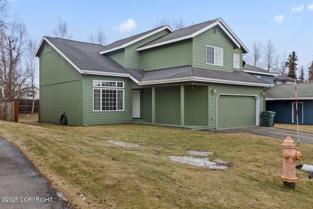 traditional home featuring a garage, a front yard, fence, and aphalt driveway