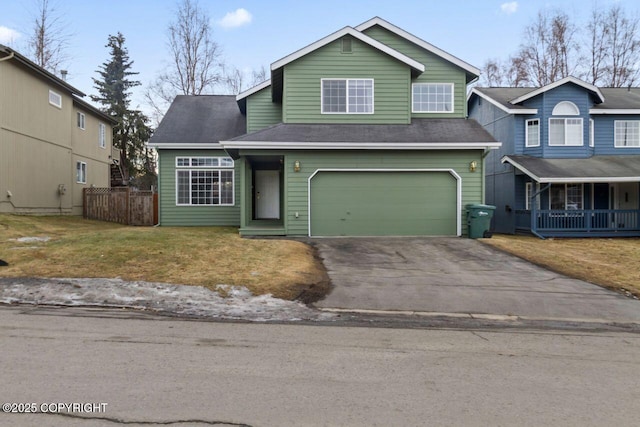 traditional-style home with a garage, covered porch, fence, driveway, and a front yard