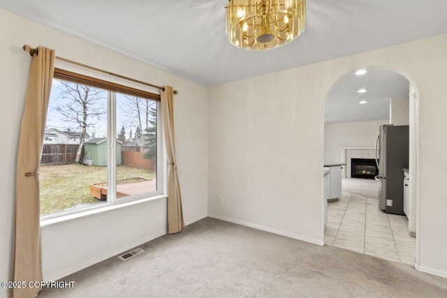 spare room with arched walkways, recessed lighting, visible vents, light carpet, and baseboards