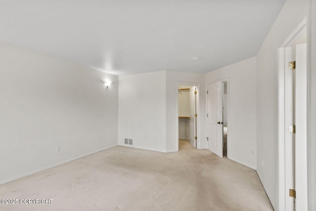 empty room with light carpet, visible vents, and baseboards