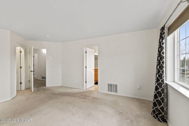 unfurnished room featuring carpet floors, visible vents, and baseboards