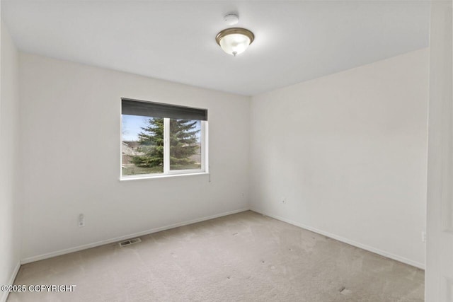 spare room with carpet, visible vents, and baseboards