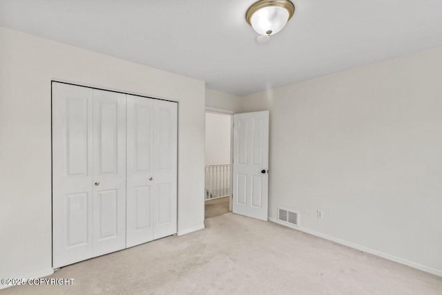 unfurnished bedroom featuring baseboards, carpet, visible vents, and a closet