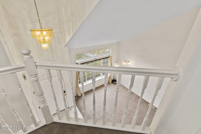 stairway featuring a chandelier and carpet flooring