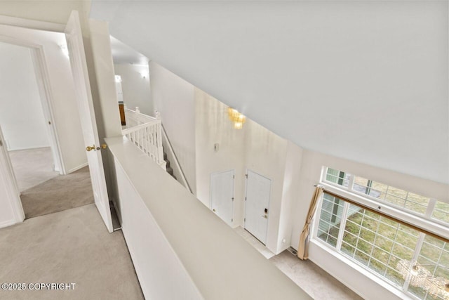 hall with lofted ceiling and carpet