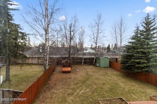 view of yard with a shed, a fenced backyard, and an outdoor structure