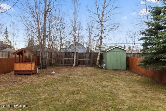 view of yard featuring an outbuilding, a shed, and a fenced backyard