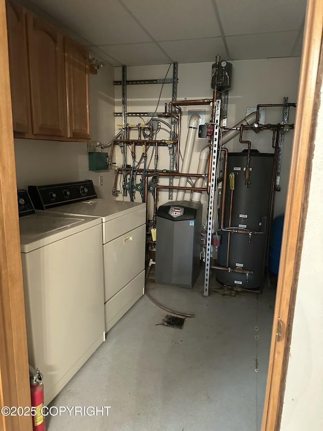 washroom with cabinet space, hybrid water heater, and washing machine and clothes dryer