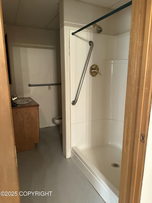 full bath with concrete flooring, vanity, a shower stall, and toilet