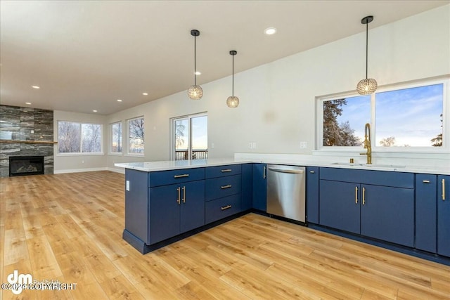 kitchen with a sink, blue cabinetry, light countertops, and dishwasher