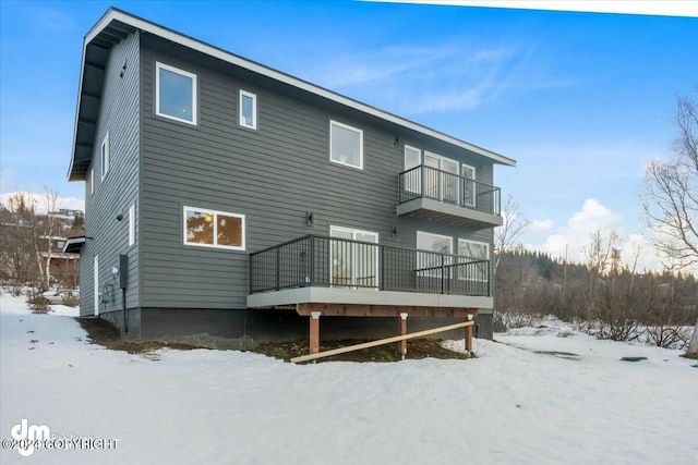 snow covered property featuring a balcony