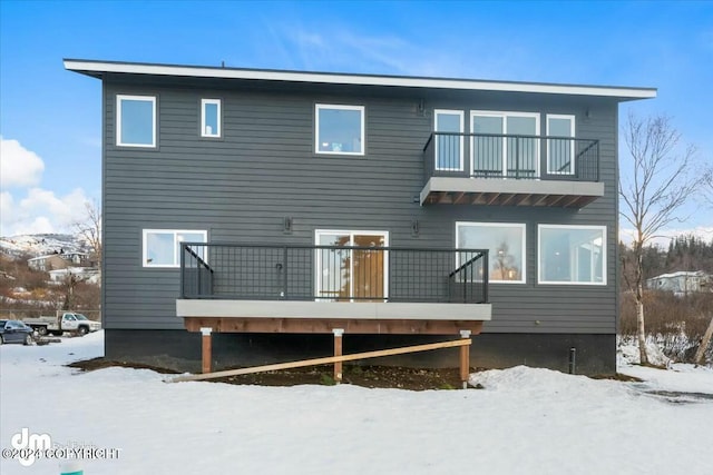 snow covered property with a balcony