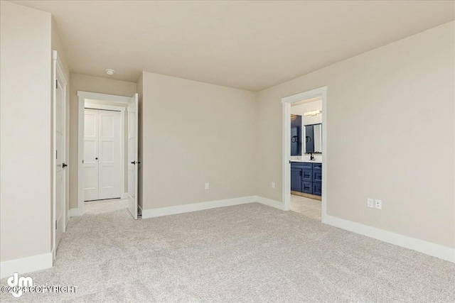 spare room featuring baseboards and light colored carpet