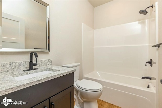 bathroom featuring wood finished floors, bathtub / shower combination, vanity, and toilet