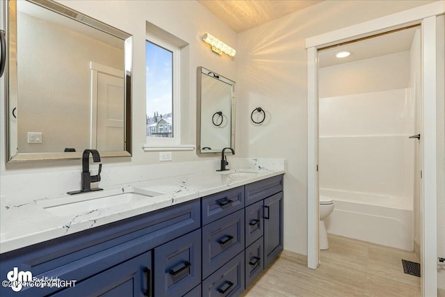 full bath with a washtub, a sink, toilet, and double vanity