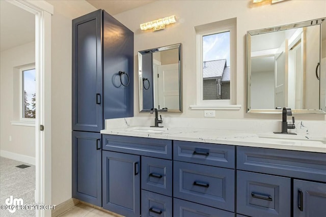 full bathroom featuring a sink, baseboards, and double vanity