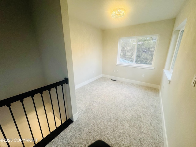 spare room with baseboards and carpet