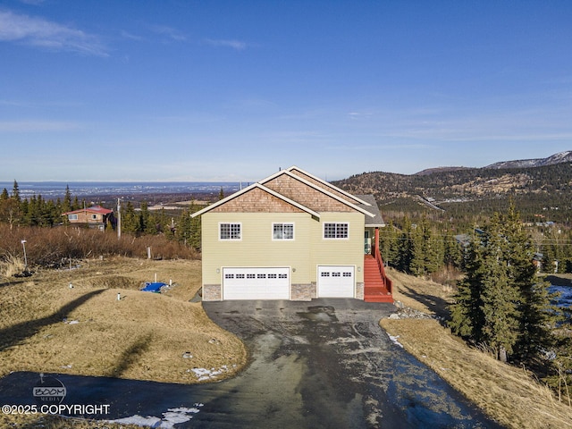 view of front of property with aphalt driveway, an attached garage, and a mountain view