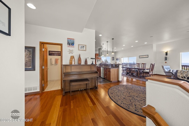 living room featuring recessed lighting, wood finished floors, and visible vents