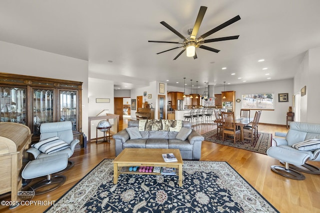 living room with a ceiling fan, recessed lighting, wood finished floors, and baseboards