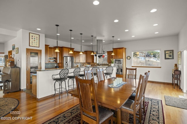 dining space featuring recessed lighting, light wood-type flooring, and baseboards