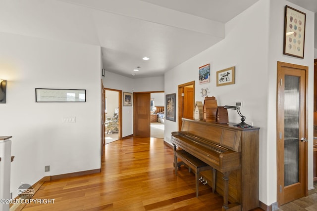 hall featuring light wood finished floors and baseboards