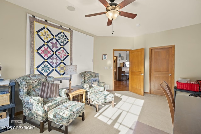 sitting room featuring light colored carpet and ceiling fan