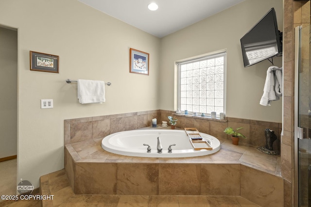 bathroom featuring a bath and tiled shower