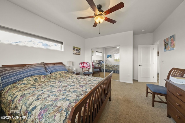 carpeted bedroom with a closet, baseboards, and a ceiling fan