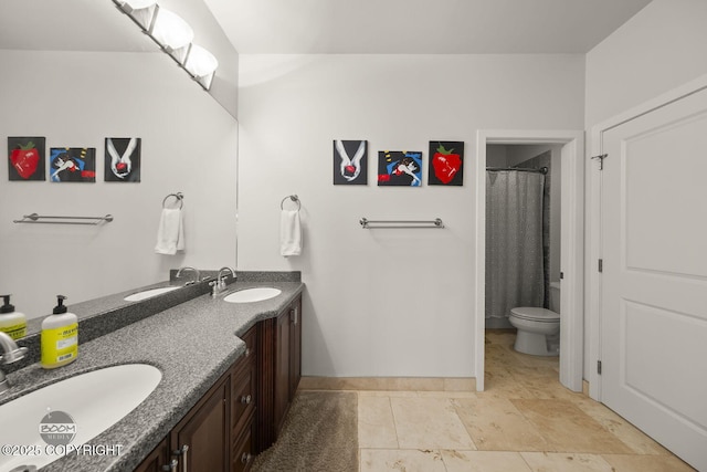 full bathroom featuring double vanity, toilet, and a sink