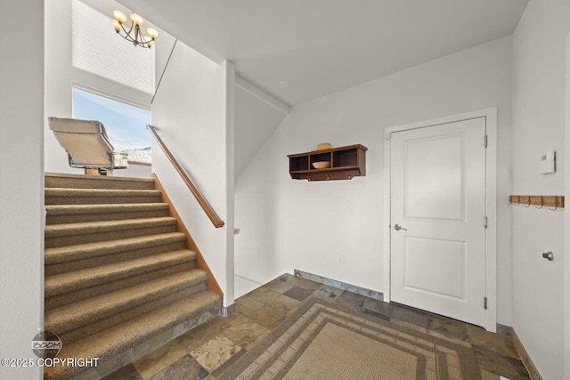 entrance foyer featuring stairs, stone finish floor, and baseboards