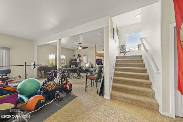 exercise room featuring carpet flooring, a ceiling fan, and a wealth of natural light