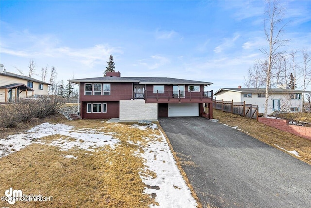 view of front of home with driveway, an attached garage, and fence