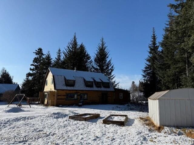 snow covered house with an outbuilding and a gambrel roof