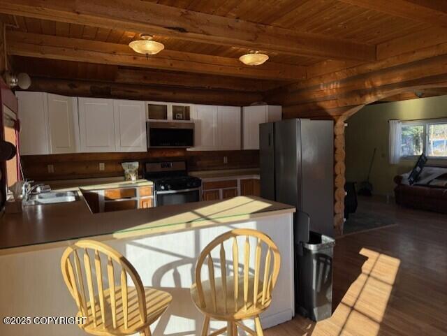 kitchen with appliances with stainless steel finishes, wooden ceiling, a sink, and beamed ceiling