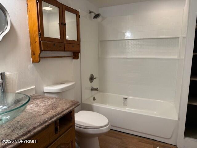 full bath with shower / bath combination, toilet, wood finished floors, and vanity