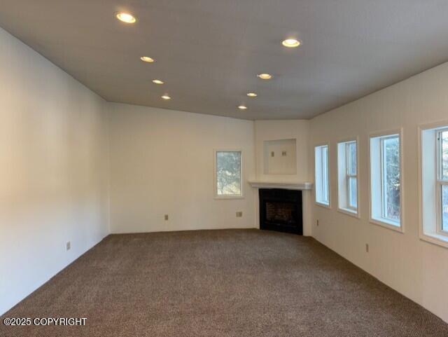 unfurnished living room featuring a fireplace, carpet flooring, and recessed lighting