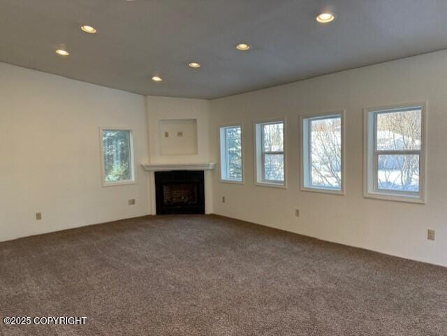 unfurnished living room featuring recessed lighting, carpet flooring, and a fireplace