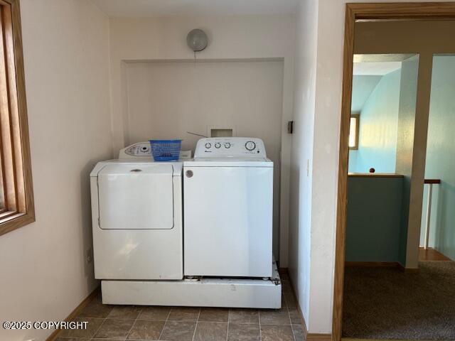 washroom with laundry area, baseboards, and washer and clothes dryer