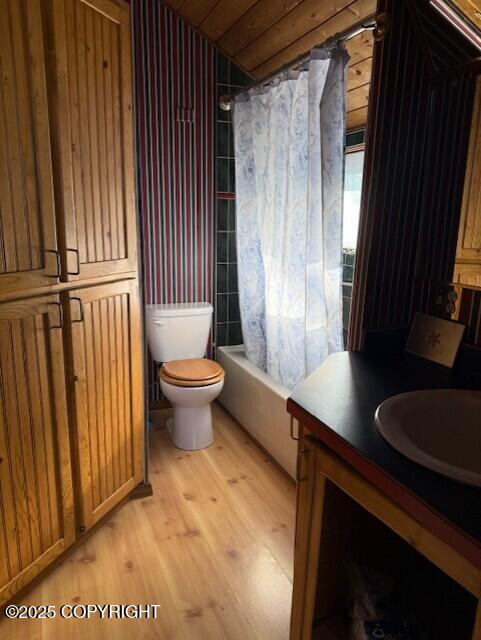 full bathroom with wooden ceiling, toilet, wood finished floors, vanity, and shower / bath combination with curtain